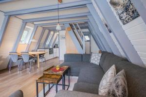 ein Wohnzimmer mit einer Couch und einem Tisch in der Unterkunft Ferienwohnpark Immenstaad am Bodensee Nurdachhaus Typ 7 ND 40 in Immenstaad am Bodensee