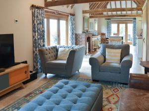 a living room with two chairs and a tv at The Cow Shed in Hooe