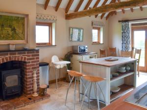 a living room with a fireplace and a stove at The Cow Shed in Hooe