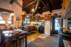 a kitchen with a table and a refrigerator and a stove at Rustic Retreat in Tílisos