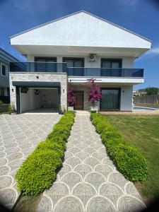 a large white house with a driveway at Villa Kalinda close to Dalaman Airport in Dalaman
