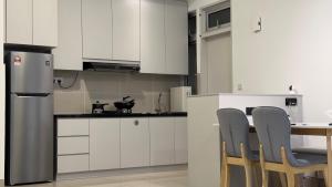 a kitchen with white cabinets and a table and chairs at Duck Duck House 3BR 7-11 PAX in Johor Bahru +29 photos