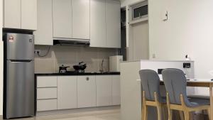 a kitchen with white cabinets and a table and chairs at Duck Duck House 3BR 7-11 PAX in Johor Bahru