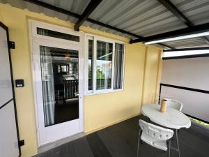 una mesa pequeña y sillas frente a una ventana en Sacha Tourist Residence 1, en Mahébourg