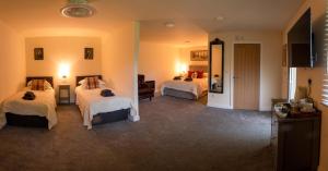 a hotel room with two beds and a television at The Moon Inn at Stoney Middleton in Stony Middleton