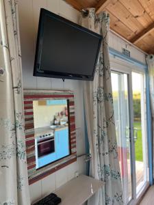 a flat screen tv on the wall of a kitchen at Reef Shepherds Hut in Penally