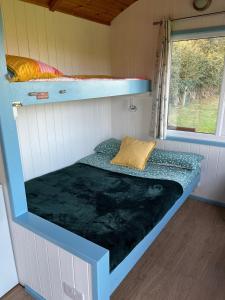 a bed in the inside of a tiny house at Reef Shepherds Hut in Penally