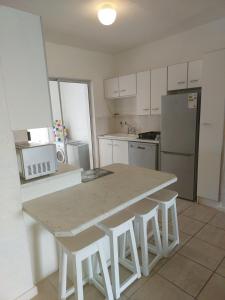 a kitchen with a table and some white appliances at OCEAN VIEW, DOLPHIN BAY 19 ASTON BAY in Jeffreys Bay