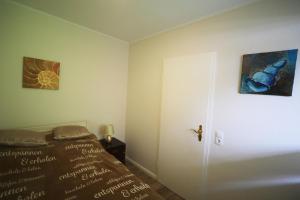 a bedroom with a bed and a door with a painting at PEMATRA Ferienwohnung Strandmuschel in Travemünde