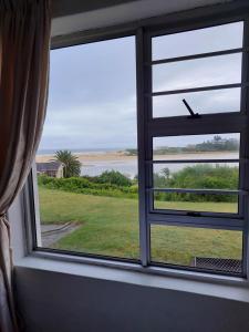 a window with a view of the ocean at OCEAN VIEW, DOLPHIN BAY 19 ASTON BAY in Jeffreys Bay