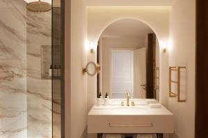 bagno con lavandino e specchio di InterContinental Rome Ambasciatori Palace, an IHG Hotel a Roma