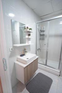 Un baño blanco con lavabo y ducha. en King Suite SS18, en Estambul