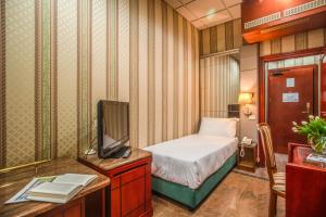 a small room with a bed and a tv at Castro Pretorio 64 Easy Rooms in Rome