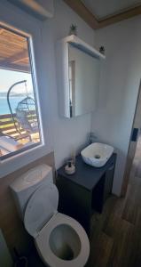a bathroom with a toilet and a sink and a window at Luxury Mobile Homes - Adria Superior in Klenovica