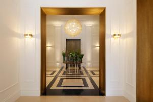 un corridoio con una porta con un lampadario a braccio di InterContinental Rome Ambasciatori Palace, an IHG Hotel a Roma