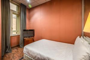 a small bedroom with a bed and a television at Castro Pretorio 64 Easy Rooms in Rome +2 photos