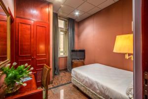 a bedroom with a bed and a desk and a television at Castro Pretorio 64 Easy Rooms in Rome