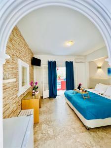 Romantic Palace Beach Apartments في آغيوس غوذيوس: غرفة نوم كبيرة بسرير ازرق وستائر زرقاء