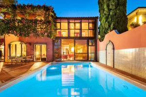 a swimming pool in front of a house at La Boheme in Taormina