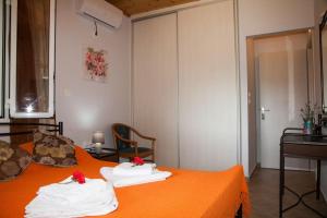 a bedroom with an orange bed with towels on it at Irini's Traditional Kefalonian House in Lixouri