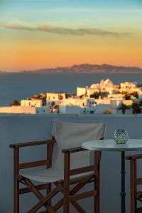 einen Tisch und Stühle mit Stadtblick in der Unterkunft Horizon Hotel in Folegandros Chora