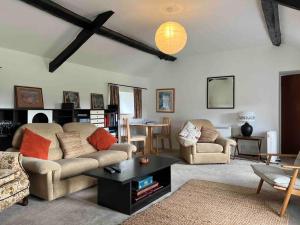 a living room with two couches and a table at Gors Eilian in Amlwch
