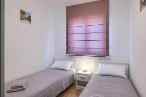 - 2 lits dans une petite chambre avec fenêtre dans l'établissement App Maria, à Pula