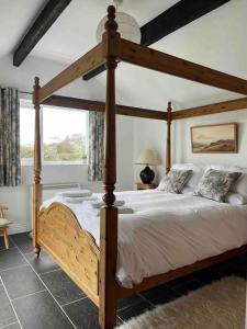 1 dormitorio con 1 cama grande de madera en una habitación en Gors Eilian, en Amlwch