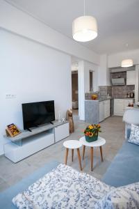 a white living room with a tv and a kitchen at Attalos luxury flat Psyrri square in Athens