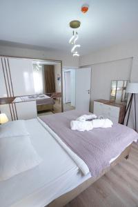 ein weißes Schlafzimmer mit einem großen Bett und einem Spiegel in der Unterkunft King Suite OJ9 in Esenyurt