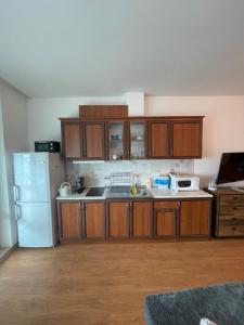 a kitchen with wooden cabinets and a white refrigerator at Studio Silver Terace with Sea View for 4 person in Byala