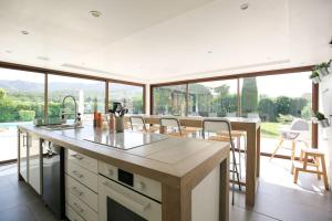 eine Küche mit einer Theke und einem großen Fenster in der Unterkunft Superbe Mas contemporain au pied du Luberon in Cheval-Blanc