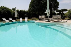 ein großer Swimmingpool mit Liegen und Sonnenschirmen in der Unterkunft Superbe Mas contemporain au pied du Luberon in Cheval-Blanc