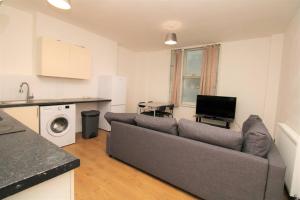 a living room with a couch and a kitchen at Ideal 2 Bed Flat close to City in London
