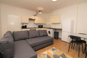 sala de estar con sofá y cocina en Ideal 2 Bed Flat close to City, en Londres