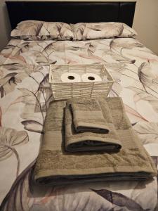 Cesta en la parte superior de una cama con toallas en Axel's Rooms 1 en Mánchester