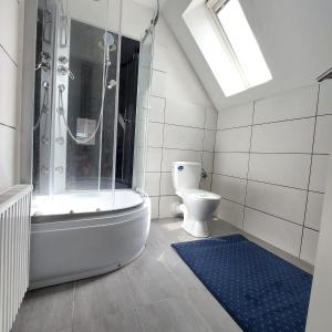 een badkamer met een bad, een toilet en een douche bij Hotel 24 in Bilstein