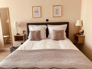 - une chambre dotée d'un grand lit avec des draps et des oreillers blancs dans l'établissement Bed and Breakfast Otentik, à Zuienkerke