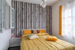 a bedroom with a large bed with a yellow comforter at Chalet Melody in Santa Croce Camerina