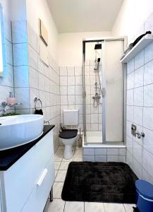 uma casa de banho com um lavatório, um WC e um chuveiro em Elbling Apartment mit Terrasse - Netflix - Parkplatz - Weinbergblick em Meißen