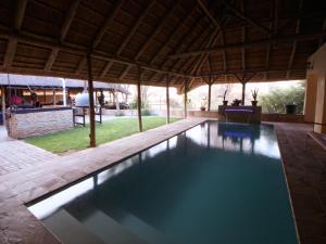 a swimming pool in a house with a roof at Uitkyk Guest Farm in Usakos