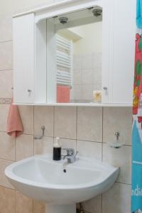 bagno con lavandino bianco e specchio di Aurelia Apartment a Lixouri