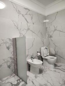 marmurową łazienkę z toaletą i umywalką w obiekcie Hotel Inju w mieście Borowoje