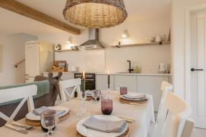 a dining room with a table with plates and wine glasses at Angram Cottage in Thirsk