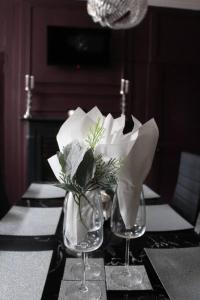 a table with two wine glasses and a vase of flowers at CARAMBOLA LUXURY AIR BNB IN THE HEART OF BEVERLEY in Beverley