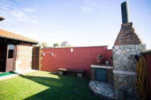 a backyard with a stone fireplace and a bench at Casa independiente con chimena, jardín y barbacoa in Santander