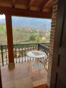 a room with a balcony with a table and chairs at Apartamentos El Ardinal in Arenas de Cabrales