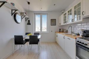 a kitchen with a table and chairs and a window at Downtown Apartments Angielska Grobla Street in Gdańsk