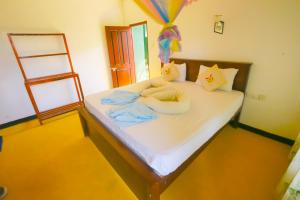 a bedroom with a large white bed with a ladder at Casa Ninearch Villa in Ella
