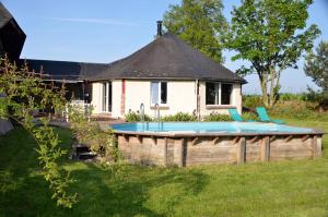 une maison avec une piscine dans une cour dans l'établissement Gîte le Manège Normand, à Grand Camp